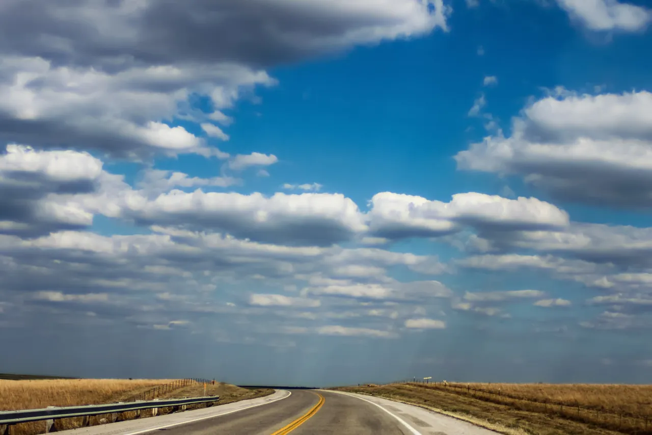 A country road over rolling green hills in northeast Oklahoma.
